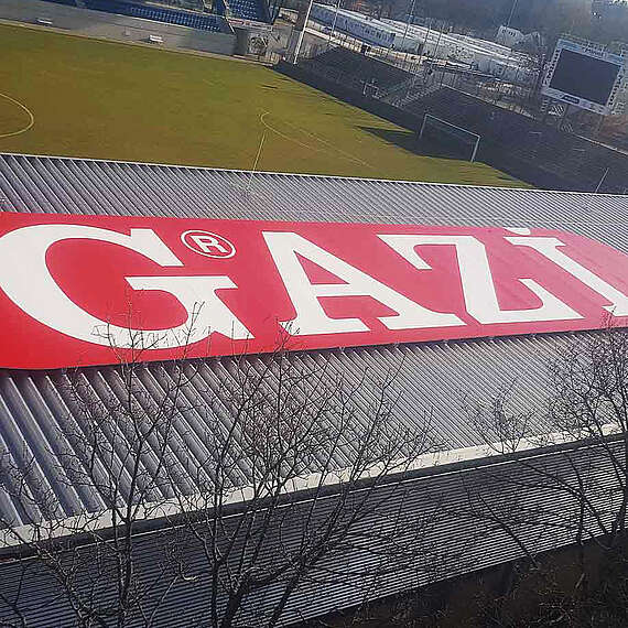 Werbeschild der Firma GAZI auf Stadiondach in Stuttgart