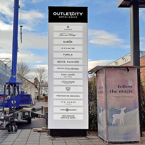 Werbepylon hinterleuchtet als Sammelwegweiser für Markenmotive Outletcity